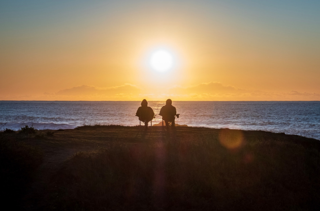 a retired couple looking into the sunset